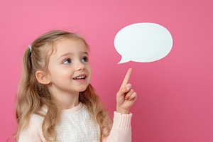 Young girl points and smiles against a vibrant pink background while thinking o, a Person Photo by AlyaAnd