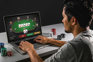 Man playing online poker with chips at desk, a Sports & Recreation Photo by Davizro's Market