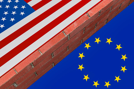 Brick wall dividing United States and European Union flags