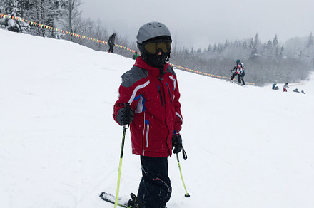 Young skier in red jacket enjoying a snowy winter day on the slopes, a Photo by AS photostudio
