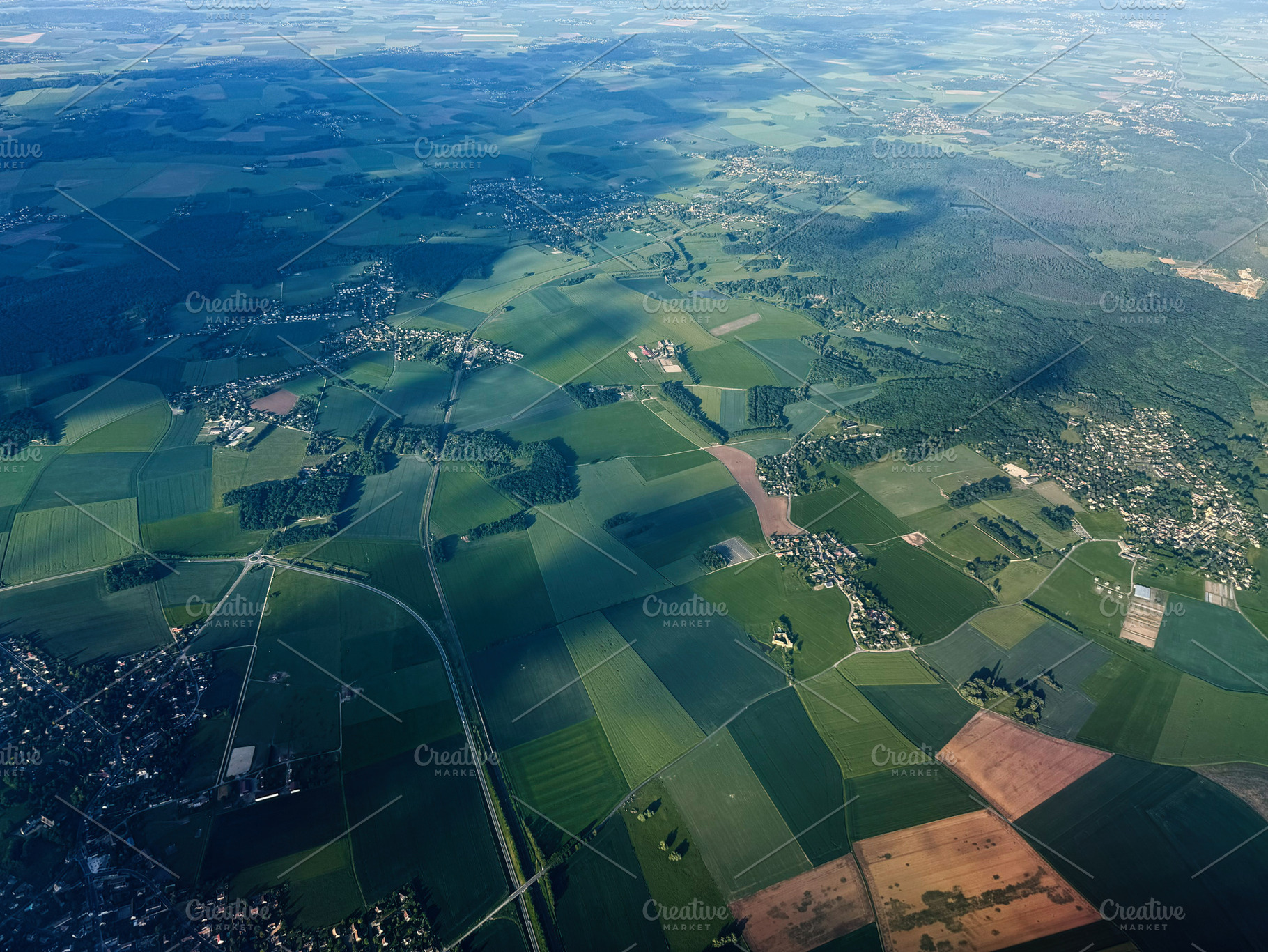 Aerial view of patchwork fields and villages near Paris, France with sunlight a, a Photo by AS photostudio