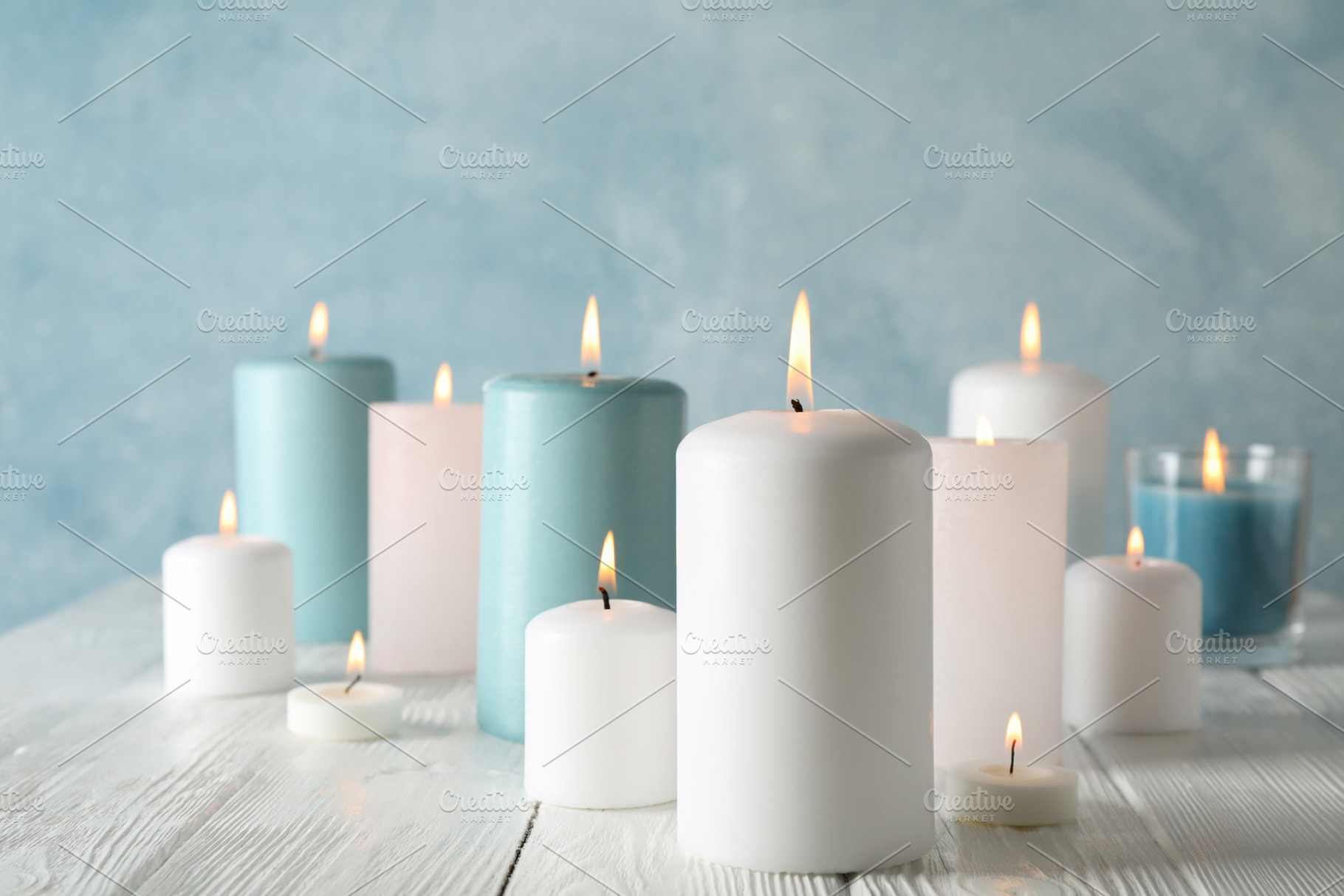Different burning candles against blue background, space for tex, a Beauty & Fashion Photo by AtlasStudio PRO