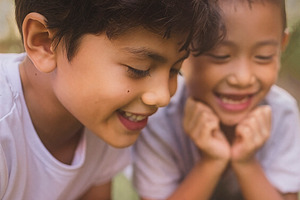Children lying on grass watching gecko, a Person Photo by DanFLCreativo