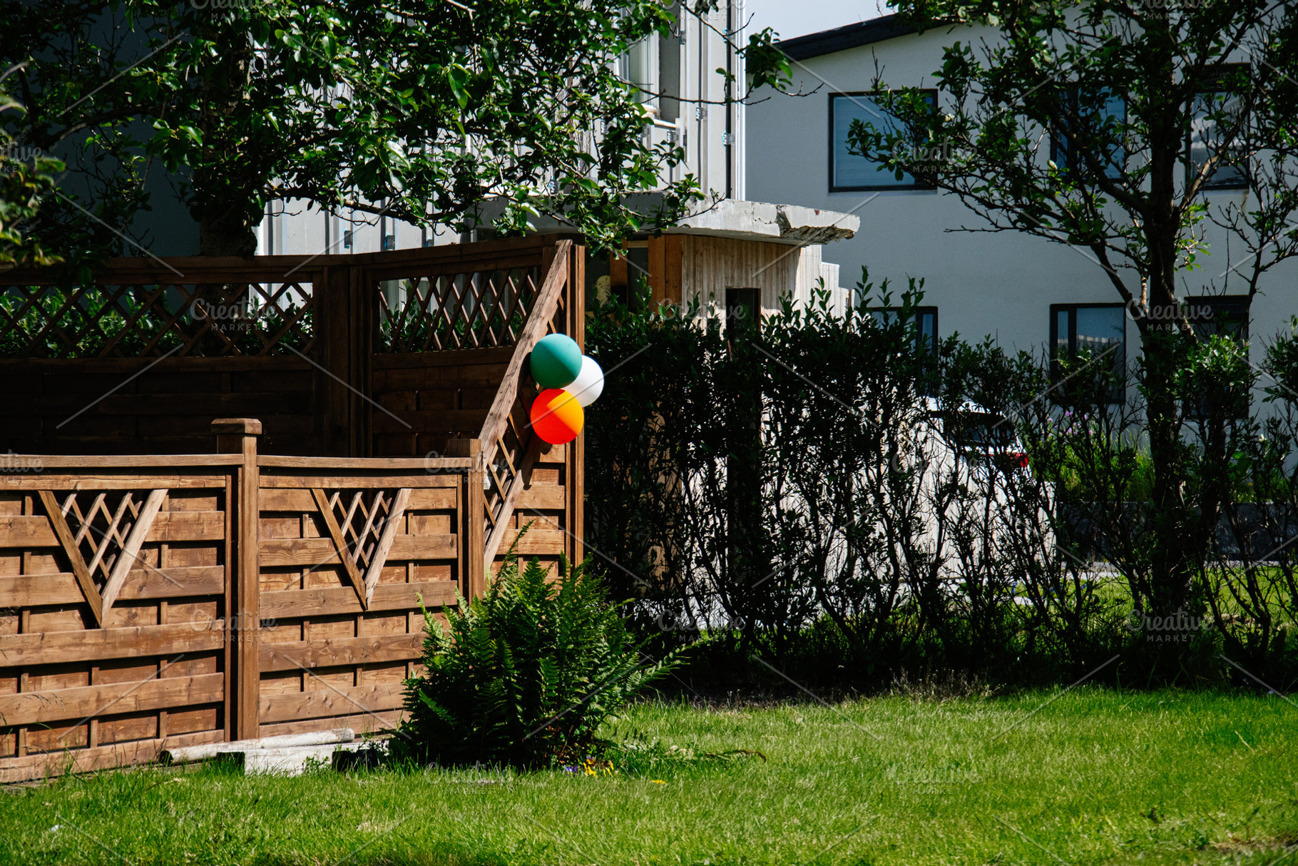 Colorful balloons hanging in a garden in Akranes, Iceland on a sunny day, a Photo by AS photostudio