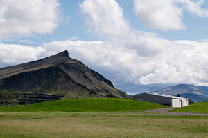 Scenic landscape of Akranes Iceland with mountain peaks and a rural building, a Photo by AS photostudio