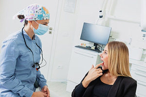 Dentist wearing surgical mask examining patient's teeth in dental clinic, a Health & Medical Photo by Antonio Gravante Market