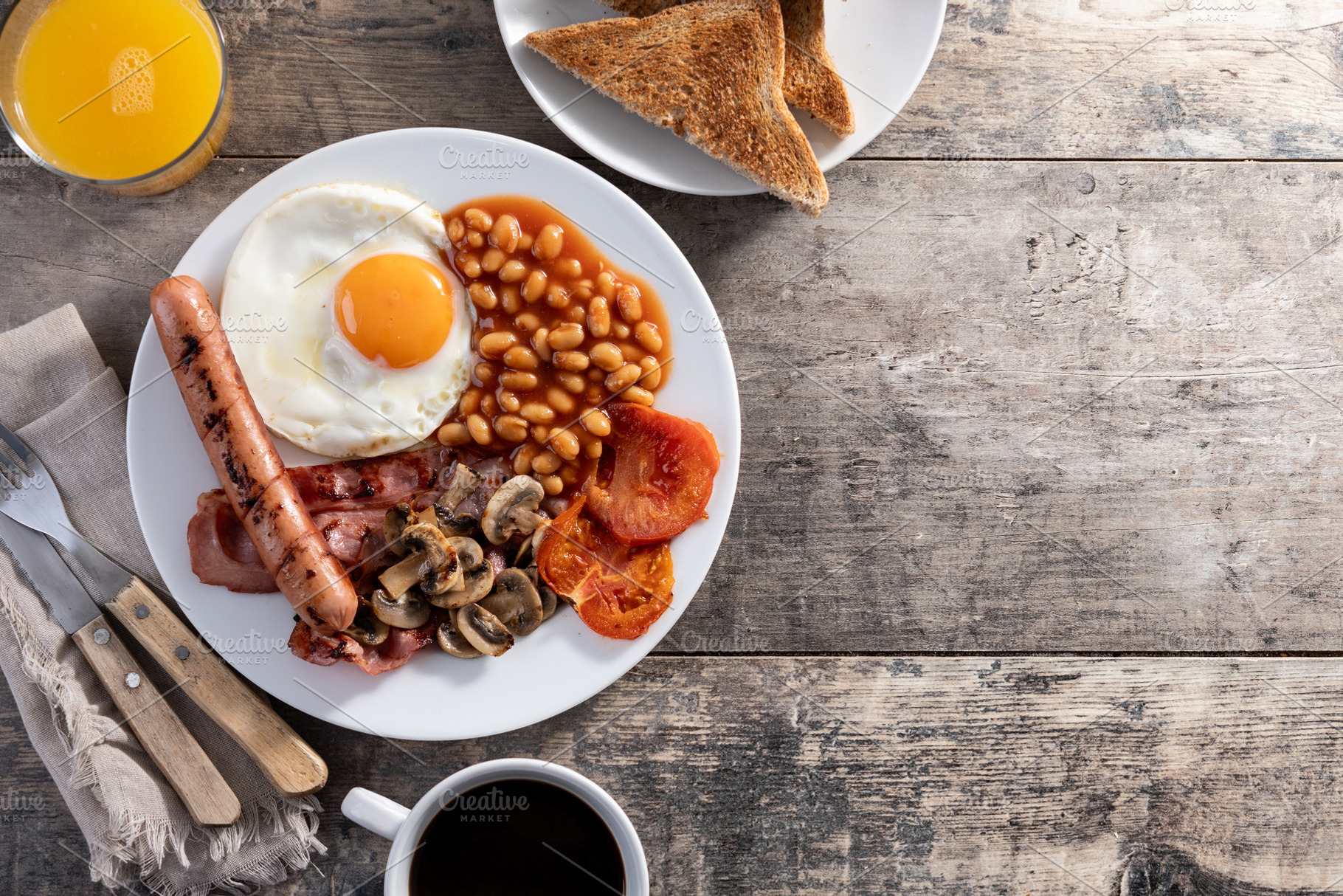 Full English breakfast with fried egg, bacon, sausages and beans, a Food & Drink Photo by etorres69