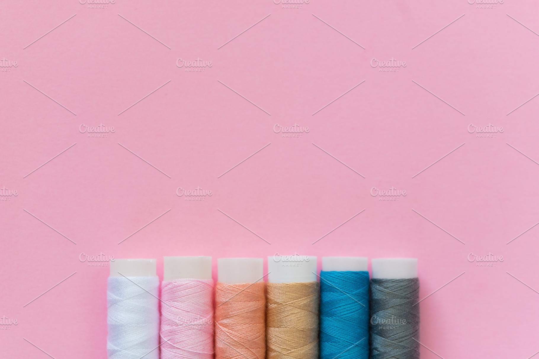 Thread spools with pink background containing thread, spool, and embroidery, an Arts & Entertainment Photo by Ekaterina Tarasenko