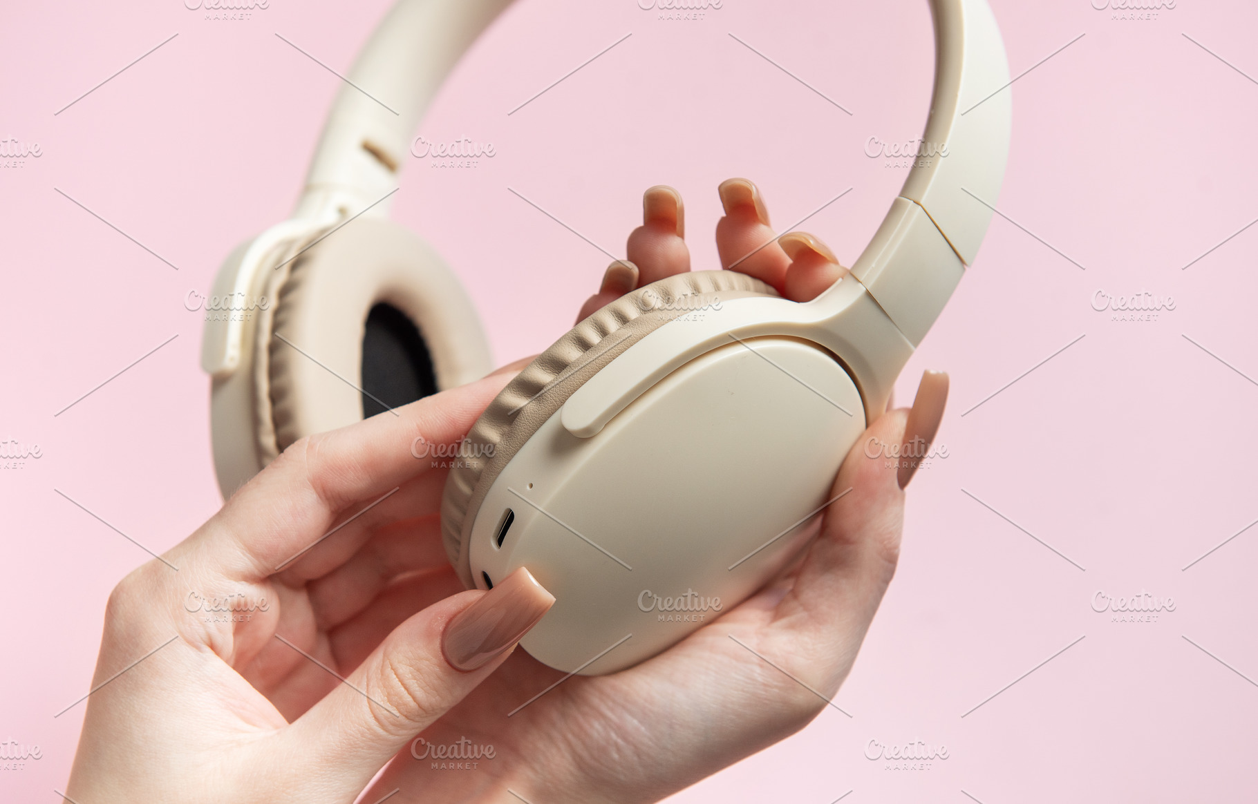 Woman holding wireless headphones on pink background, a Technology Photo by Olena Rudo
