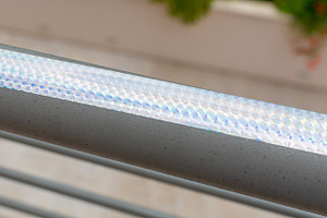 Iridescent holographic bird repellent tape reflecting sunlight on a railing, an Abstract Photo by Antonio Gravante Market