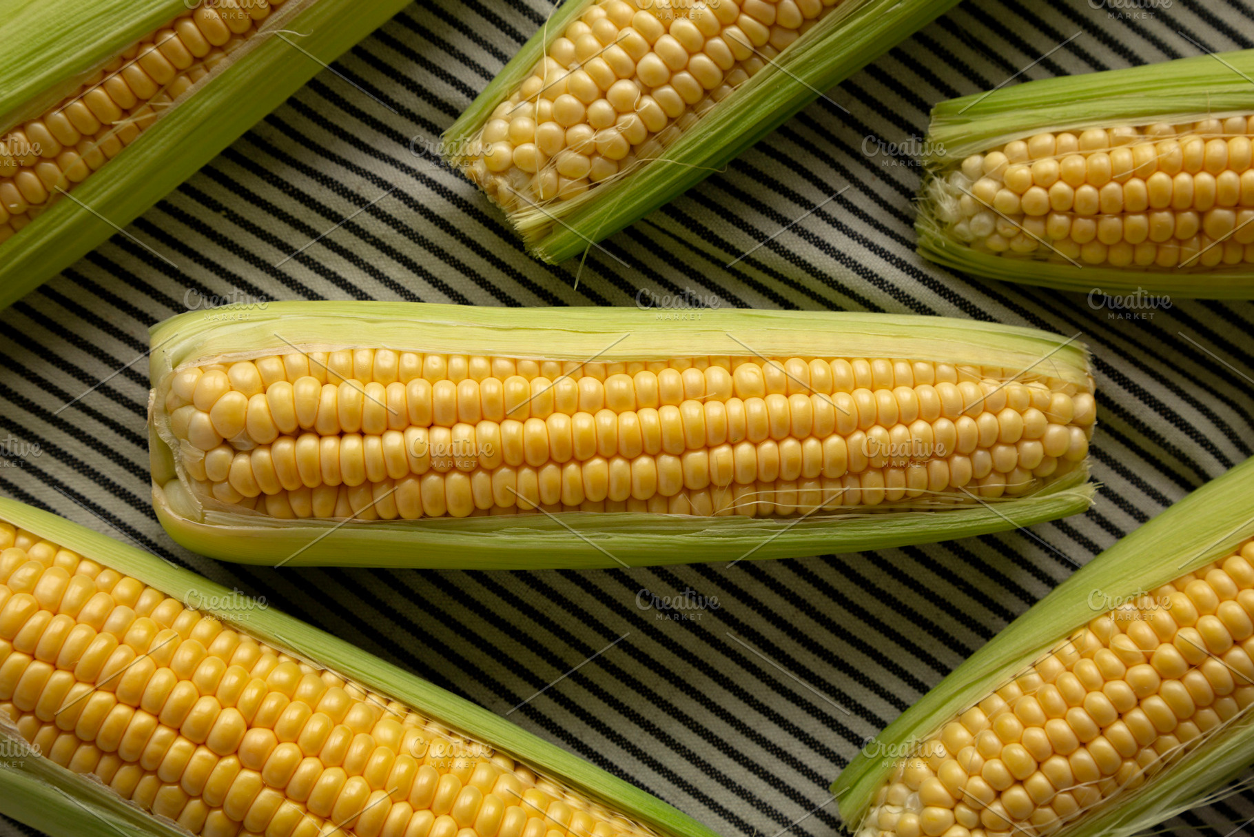 Fresh Raw Organic Corn on the Cob in the Husk, top view., a Food & Drink Photo by LiudmylaChuhunova