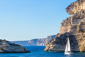 Sailboat navigating between rocky cl, a Photo by Dvoevnore photos