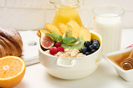 plate with oatmeal and fruit, half a ripe orange and freshly squ, a Food & Drink Photo by ndanko