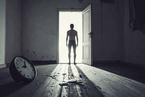 Man standing in dark room looking towards bright open doorway, a Person Photo by DanFLCreativo