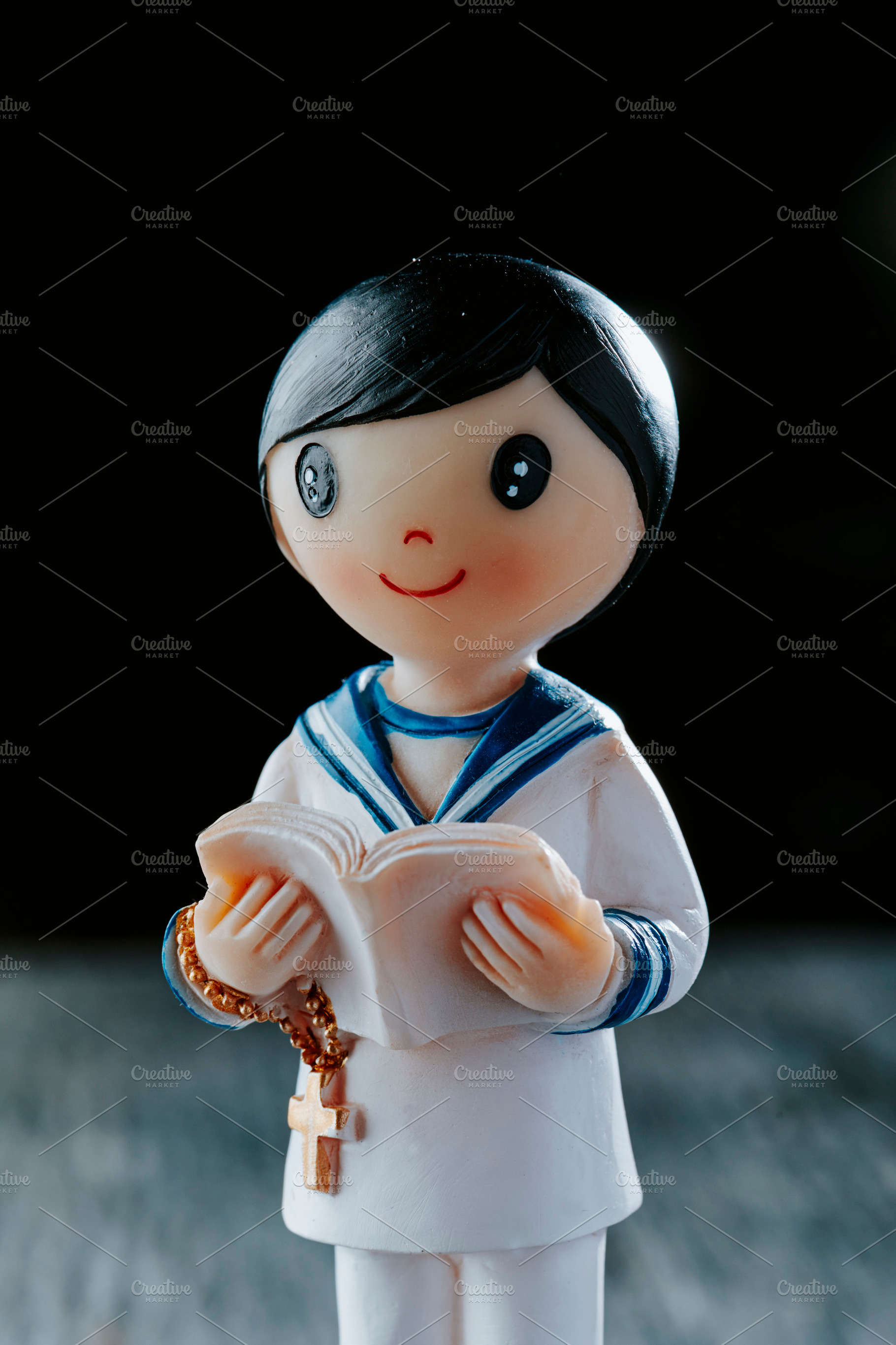 closeup of a figurine of a first communion boy, a Photo by Nito