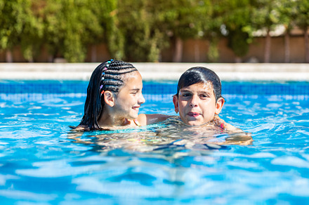 Portrait of two young kids into a swimming pool, a Person Photo by Cosca
