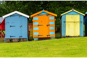 Three painted colourful beach huts, a Holiday Photo by Backyard Stock