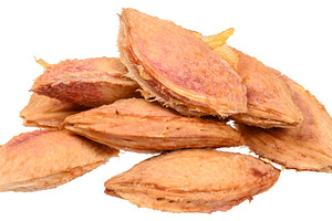 A small pile of dried plum pits with a fibrous texture and detai
