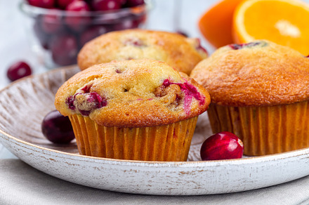 Homemade cranberry orange muffins on wooden plate, horizontal, closeup, a Food & Drink Photo by iuliia_n