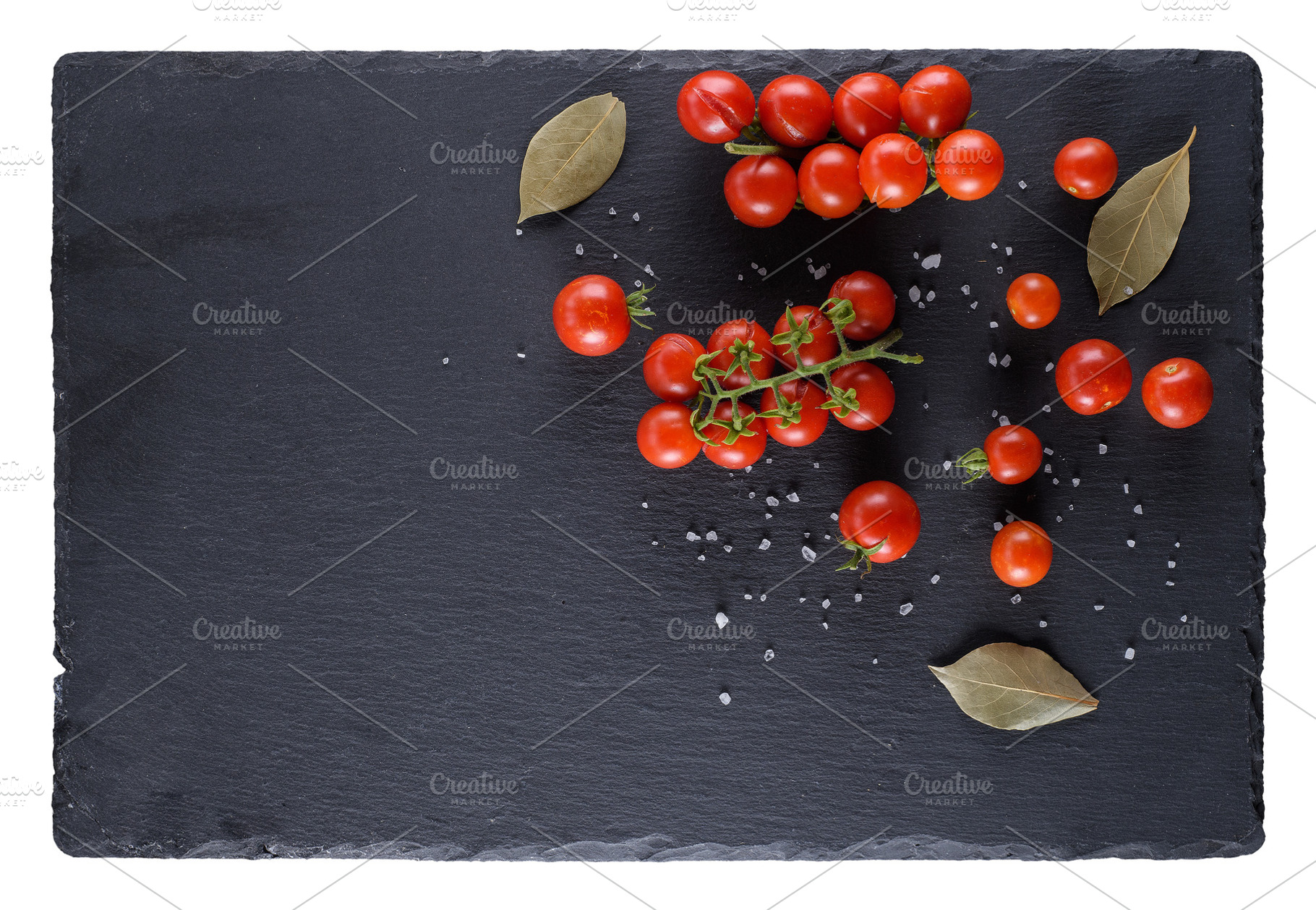 Cherry tomatoes and spices on a black slate board, top view, a Photo by ndanko