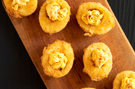 Homemade Deep-fried Deviled Eggs with Paprika on a rustic wooden, a Food & Drink Photo by LiudmylaChuhunova