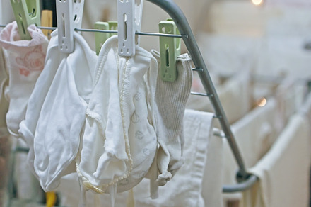 Baby's clothes, bodysuits and pants are dried after the laundry. Organization a, an Industrial Photo by TanaCh