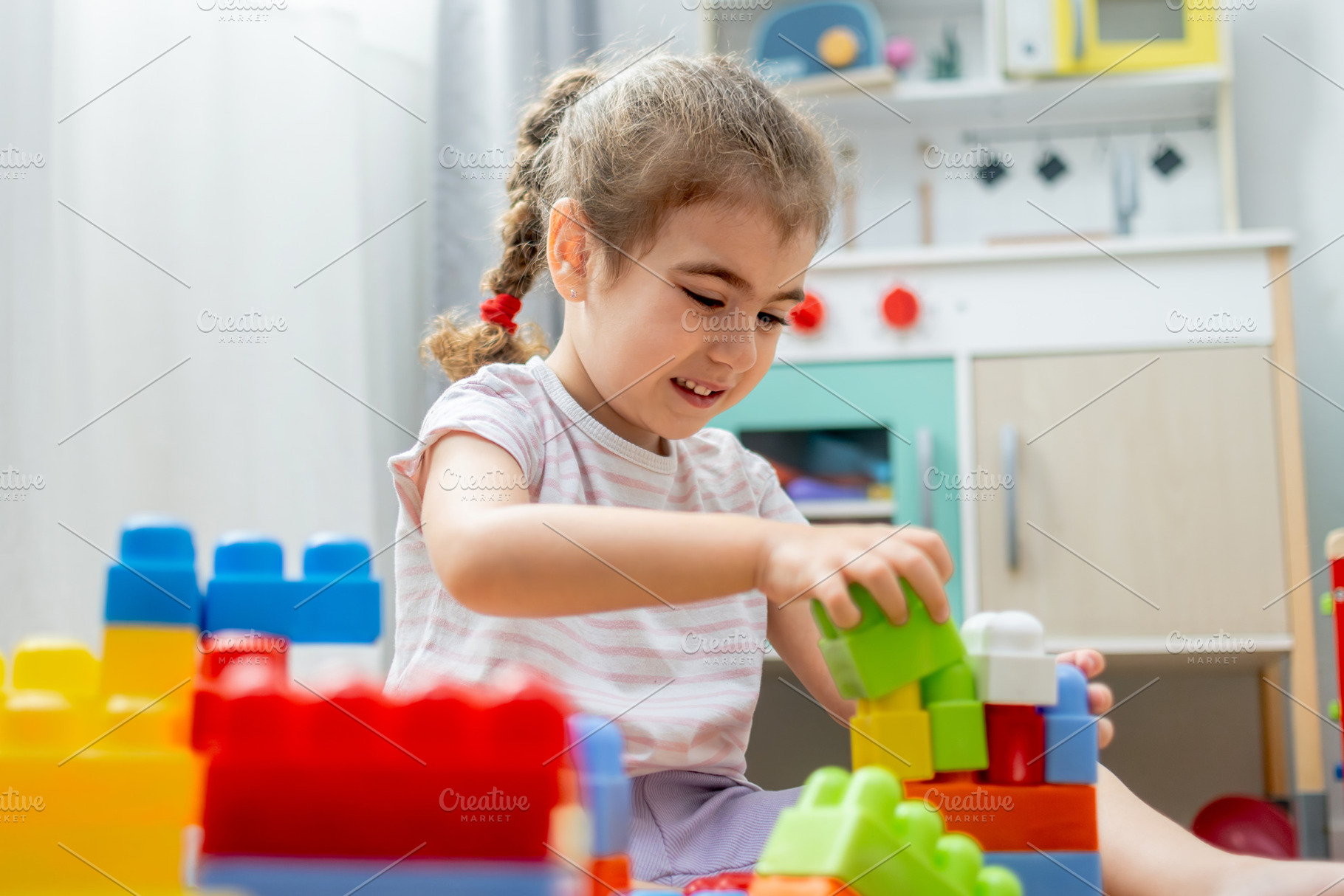 Little girl building colorful block tower on floor at home, a Person Photo by etorres69