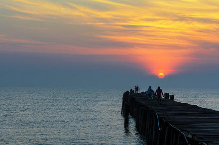 Sea at sunrise containing sunrise, sea, and bridge, a Nature Photo by yongkiet jitwattanatam