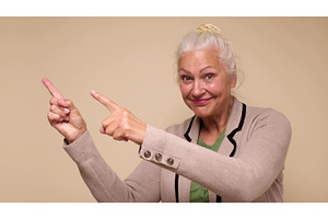 An elderly woman points her finger