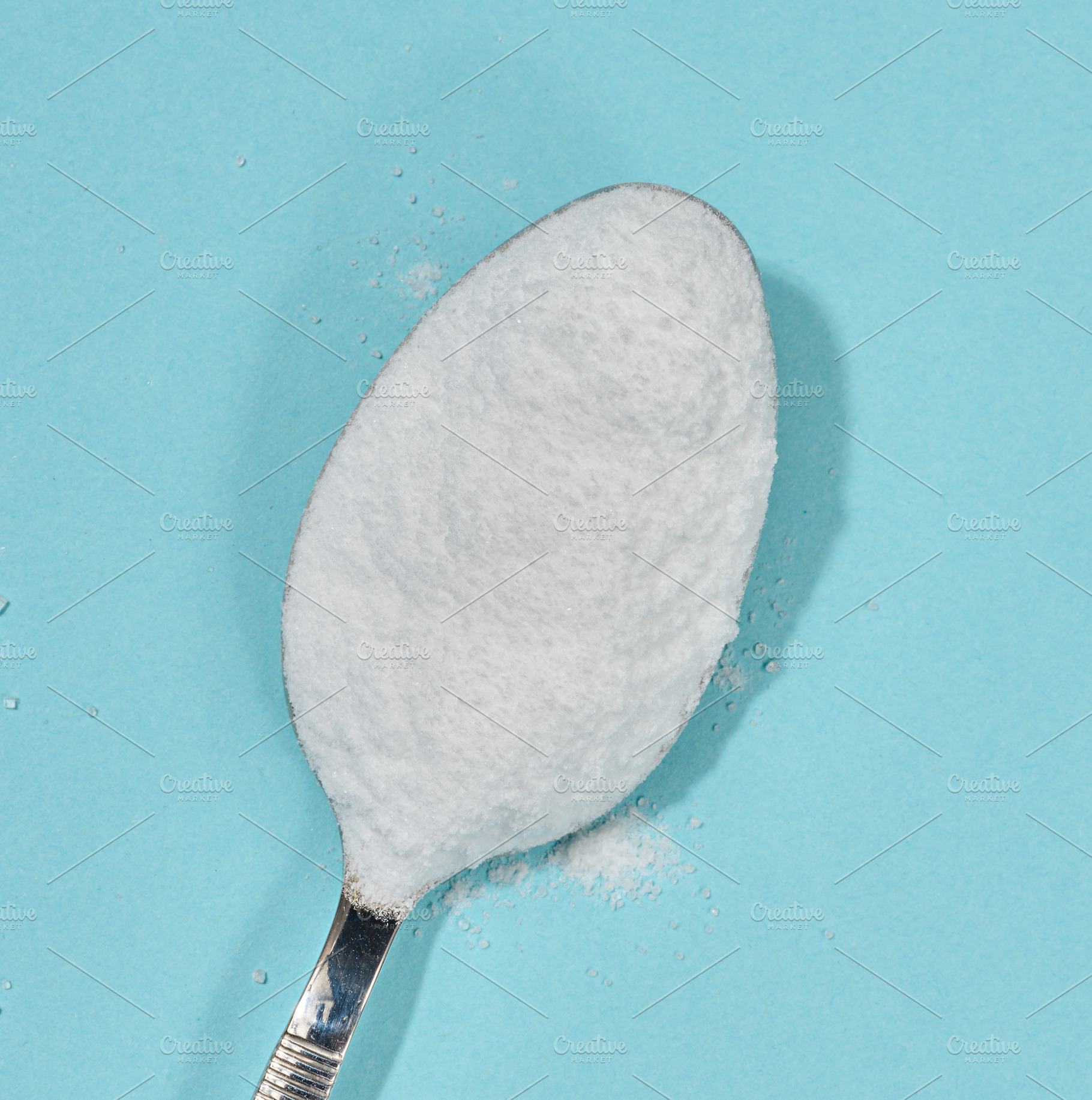 A tablespoon filled with white crystal sugar, close-up on a cont, a Food & Drink Photo by ndanko