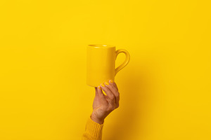 Hand with yellow nails and sweater holding a plain yellow mug ag, a Food & Drink Photo by Ales Munt