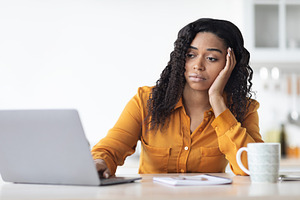 Upset young african american woman looking for job on Internet