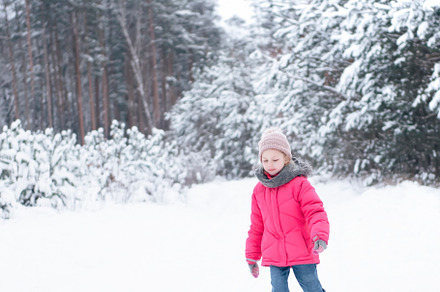 Little girl in a bright jacket plays in the winter forest, a Person Photo by Olena Rudo