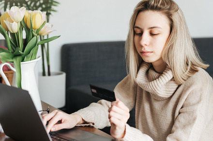 Young woman holding credit card and using laptop., a Person Photo by Olena Rudo
