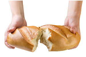 Loaf of bread in hands broken in, a Food & Drink Photo by innakreativ