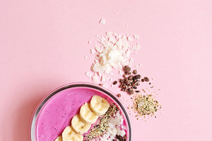 Pink smoothie bowl on pink backgroun stock photo containing smoothie and