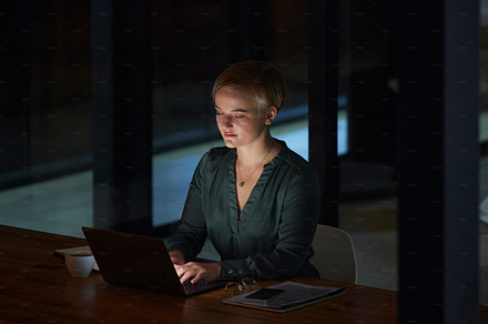 Night, laptop and typing with woman in office for planning, overtime and corporate strategy. Deadline, technology and email with employee at desk for business proposal, online trading and internet, a Photo by Peopleimages.com