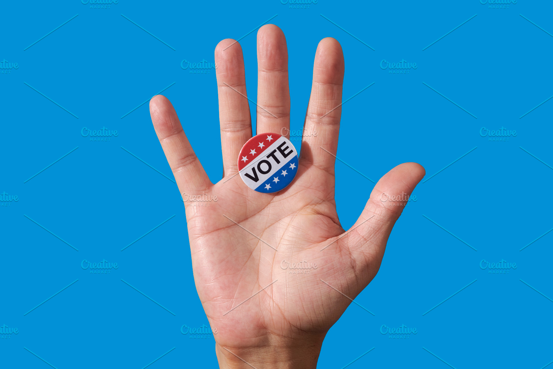 a vote badge on the open palm of a man, a Photo by Nito