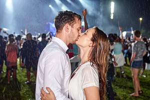Young couple kisses passionately under torrential rain at an out, a Person Photo by DanFLCreativo