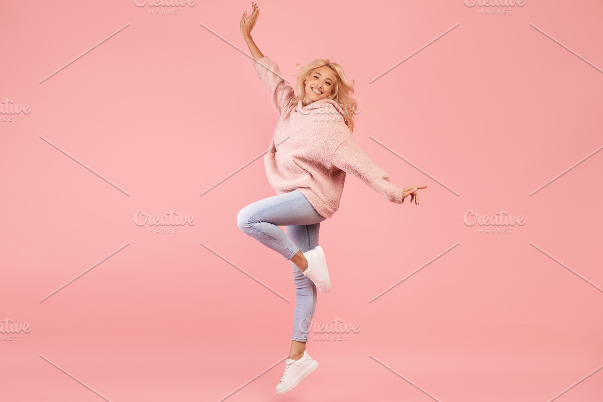 Playful caucasian woman jumping and having fun over pink studio background, lad, a Photo by Prostock-Studio (Photo 3 of 3)