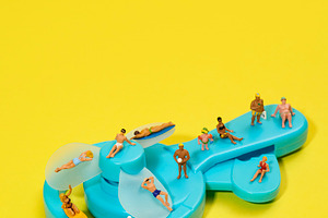 miniature people in swimsuits on a blue fan, a Photo by Nito