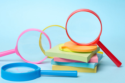 Multicolored plastic magnifying glasses on a blue background and, a Business Photo by ndanko