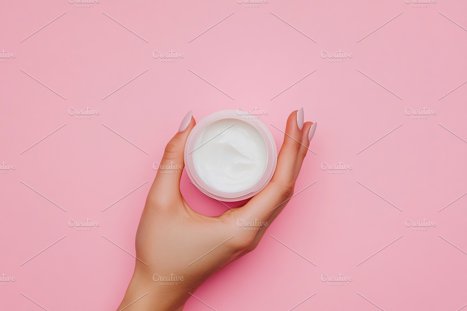 Female model hand holding cosmetic jar on pink background, a Beauty & Fashion Photo by AlyaAnd