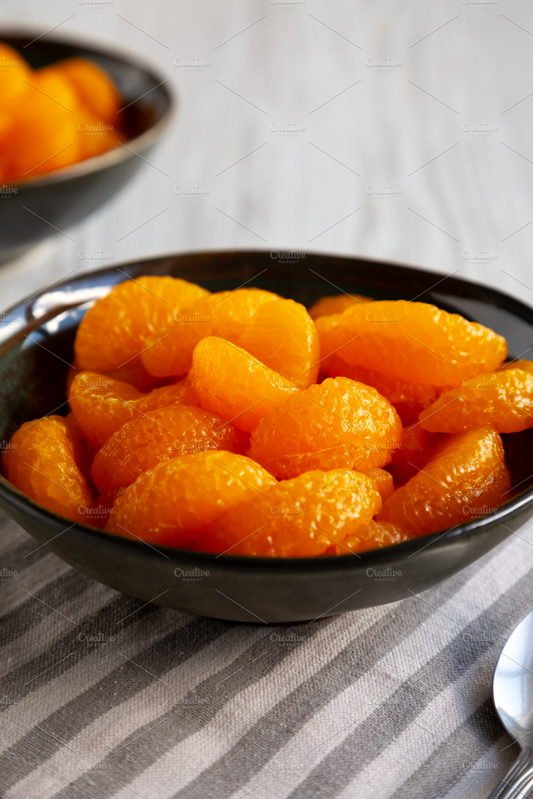 Organic Canned Mandarin Oranges in Bowls, side view. Close-up., a Food & Drink Photo by LiudmylaChuhunova