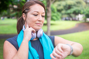 Woman checking her fitness tracker after exercising outdoors