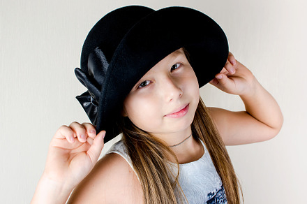 Portrait of a pretty little girl in hat posing at studio, a Person Photo by vimart