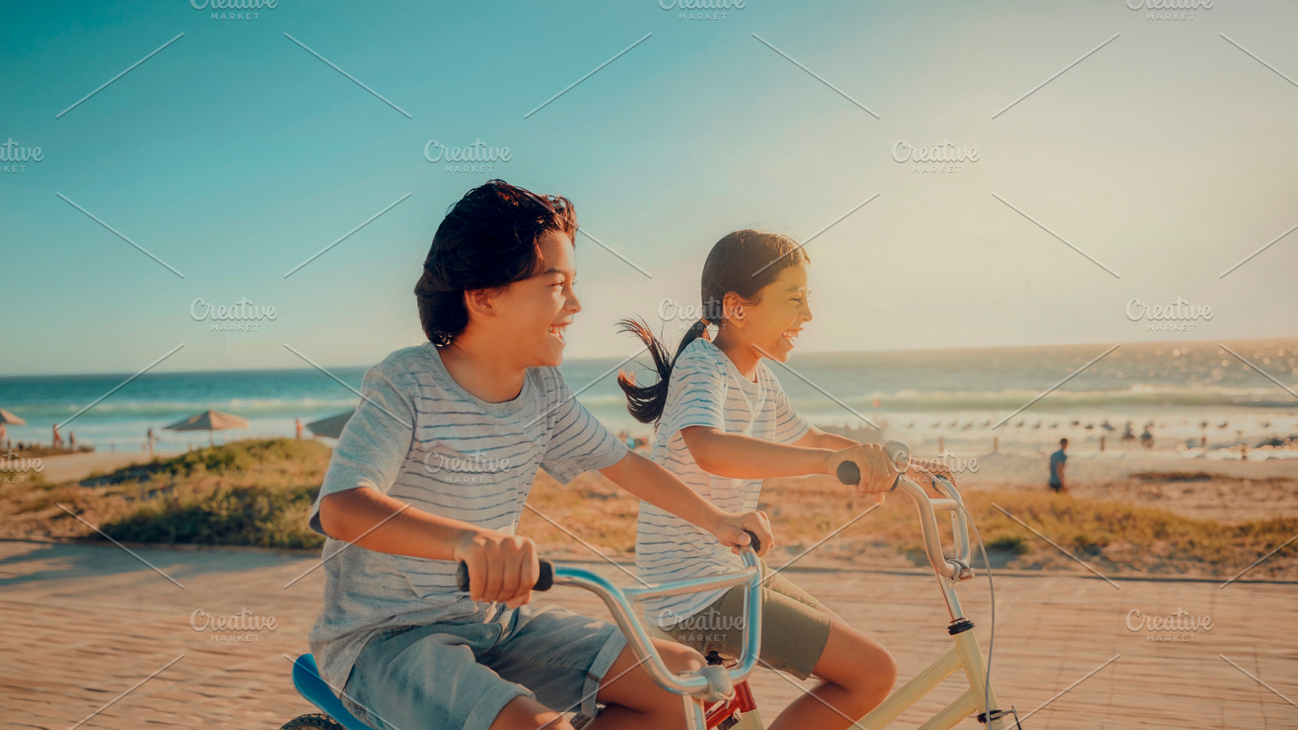 Two children riding bicycles by the beach, a Person Photo by DanFLCreativo