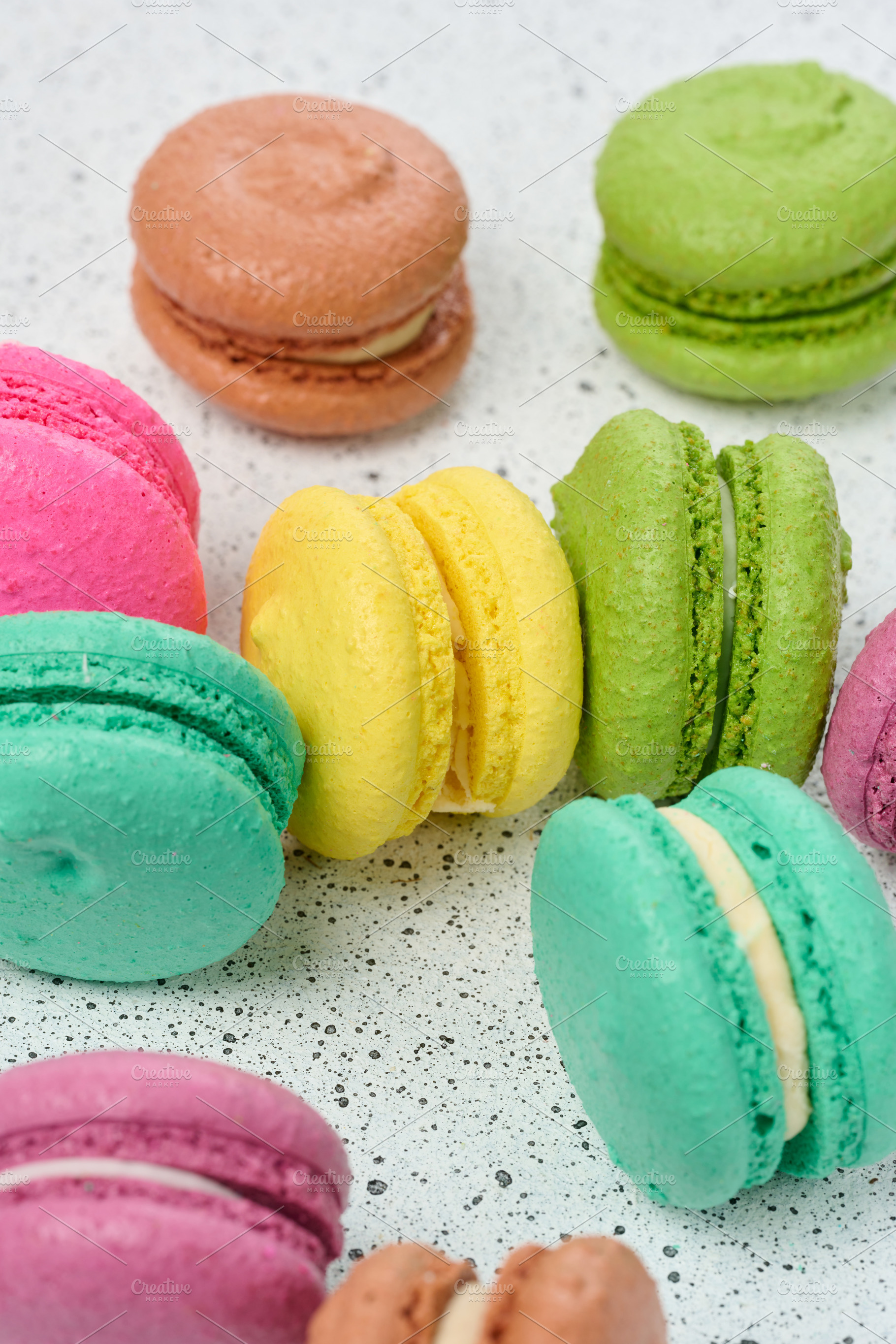 An assortment of colorful macarons on a white surface with dark, a Food & Drink Photo by ndanko