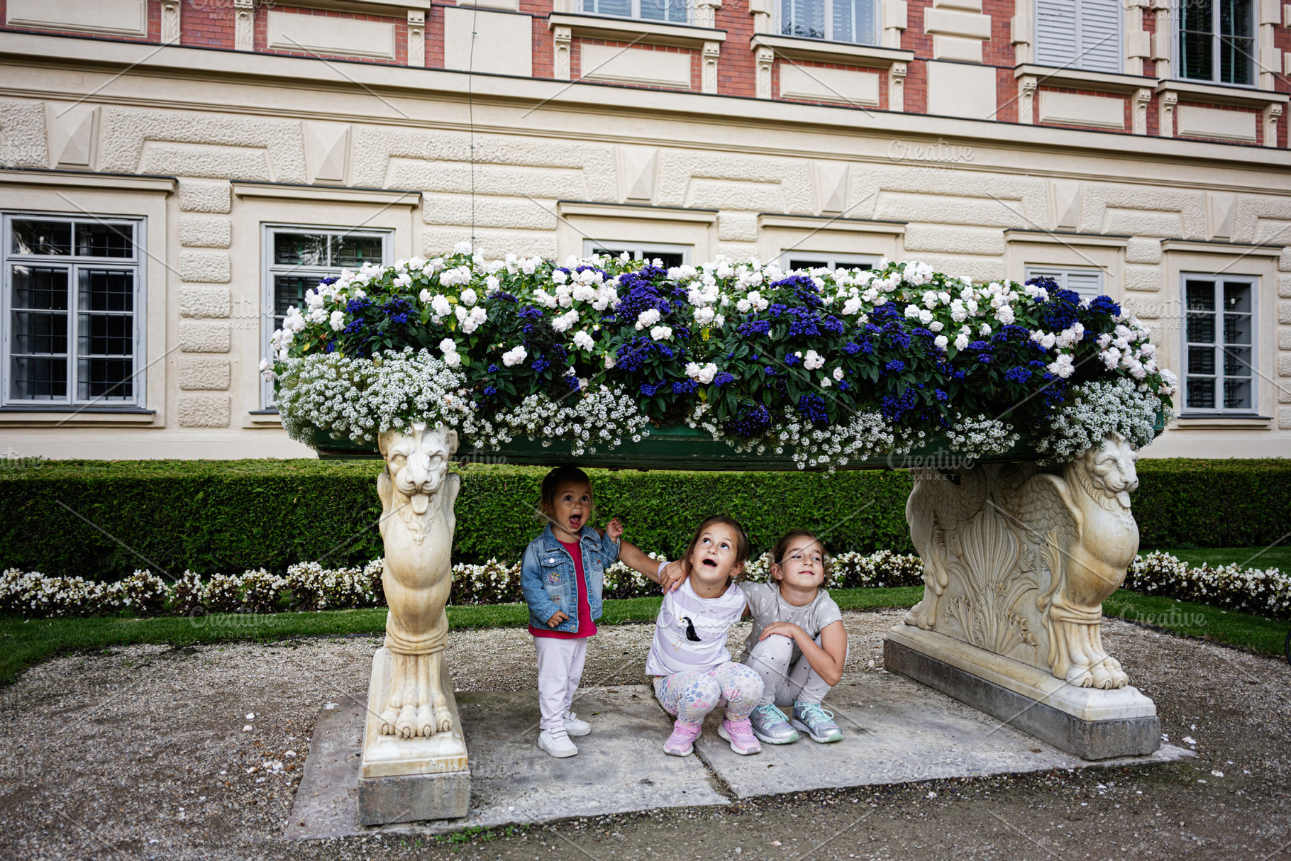 Children playing beneath a large floral arrangement in Lancut, Poland garden se, a Photo by AS photostudio