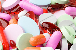 Close-up of colorful pills and capsules on white surface